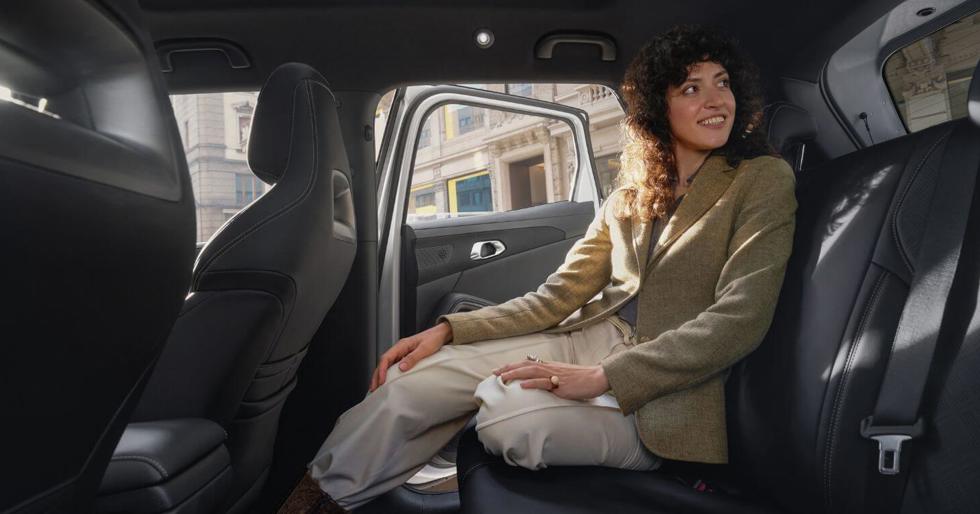 Vrouw die op de achterbank van de BYD ATTO 2 zit.